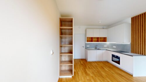 Modern kitchen with white cabinets, gray backsplash, and an open wooden shelf unit against a wooden floor. and a vertical wooden slat screen on the right.