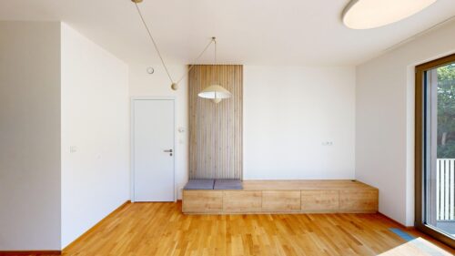 Minimalist room with a wooden bench, vertical slat panel, and modern pendant light fixtures on a white wall.